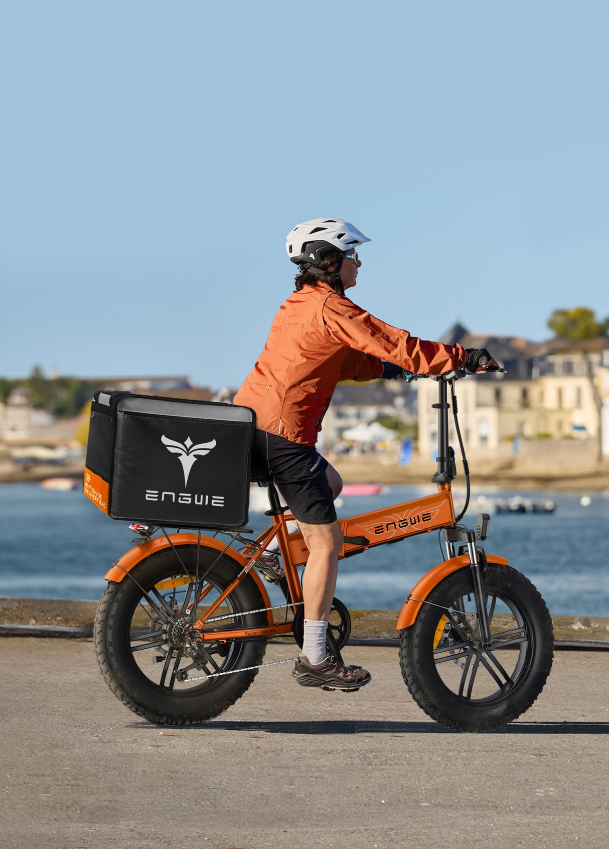 una persona in sella a una bicicletta pieghevole elettrica engwe ep-2 boost con un cestino da asporto